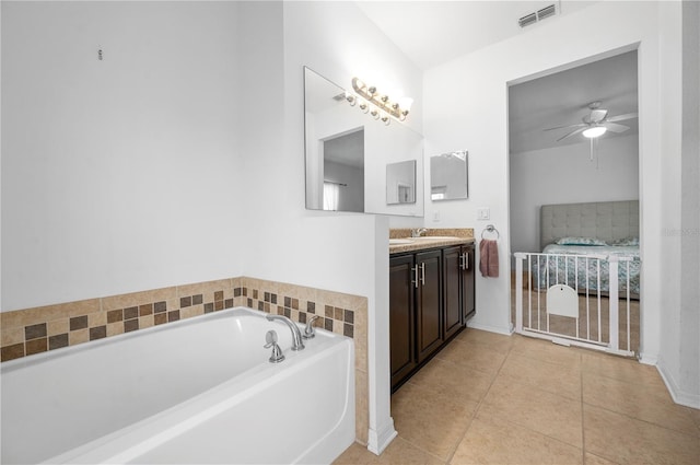 bathroom featuring tile floors, ceiling fan, a tub, and vanity