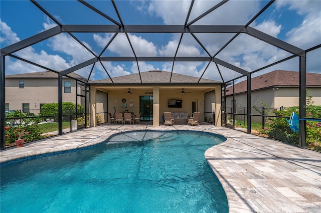 view of pool with a patio, glass enclosure, and ceiling fan