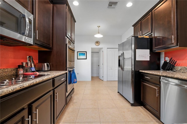 kitchen featuring stainless steel appliances, decorative light fixtures, dark brown cabinetry, light stone counters, and light tile floors