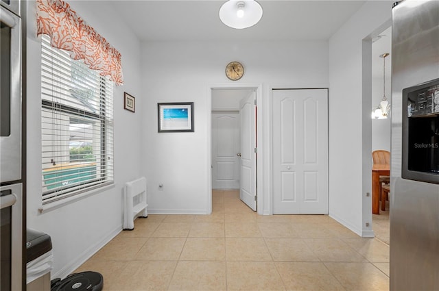 kitchen featuring radiator, decorative light fixtures, and light tile floors