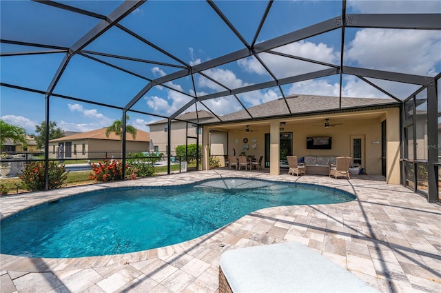 view of swimming pool featuring outdoor lounge area, glass enclosure, a patio area, and ceiling fan