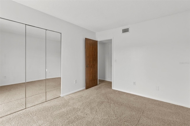 unfurnished bedroom with carpet and a closet