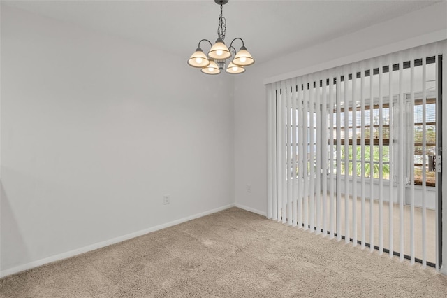 empty room featuring carpet and a notable chandelier