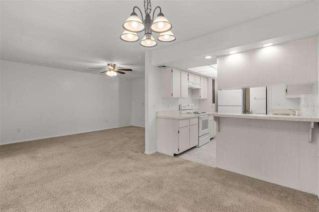 kitchen with white appliances, light carpet, white cabinets, hanging light fixtures, and kitchen peninsula