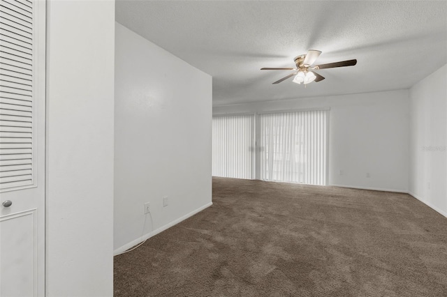 unfurnished room with dark colored carpet, ceiling fan, and a textured ceiling