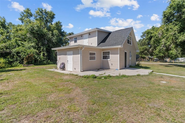 back of house featuring a lawn and a patio area