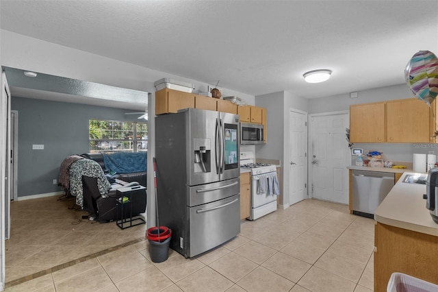 kitchen featuring ceiling fan, light tile patterned floors, and appliances with stainless steel finishes