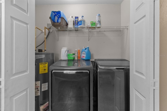 laundry room featuring water heater and washing machine and clothes dryer