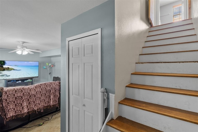 stairway featuring a wealth of natural light and ceiling fan