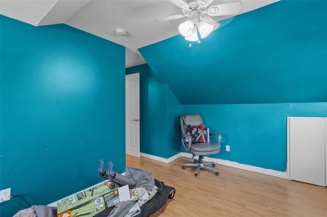 unfurnished office featuring a textured ceiling, light hardwood / wood-style floors, ceiling fan, and lofted ceiling