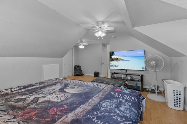 bedroom featuring ceiling fan, hardwood / wood-style floors, and vaulted ceiling