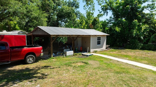 view of outbuilding with a lawn and a carport