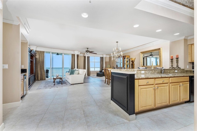 kitchen with sink, hanging light fixtures, ornamental molding, and light stone counters