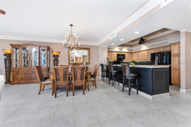 tiled dining space featuring crown molding, a raised ceiling, and a chandelier