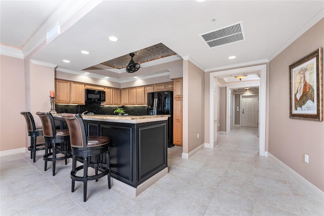 kitchen featuring a breakfast bar area, black appliances, crown molding, kitchen peninsula, and decorative backsplash