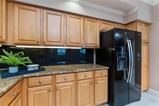 kitchen with light stone counters, black fridge, light tile patterned floors, tasteful backsplash, and crown molding