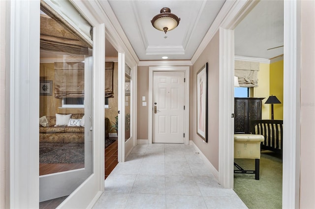 interior space featuring ornamental molding, french doors, a raised ceiling, and light tile patterned floors