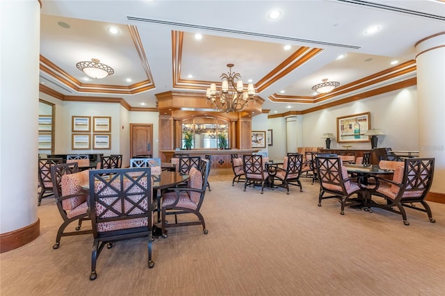 dining room featuring a chandelier, decorative columns, a tray ceiling, ornamental molding, and light carpet