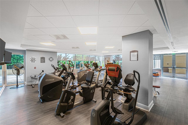 workout area with a paneled ceiling and wood-type flooring