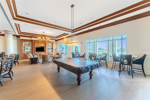 recreation room with billiards, ornamental molding, a raised ceiling, and light hardwood / wood-style flooring