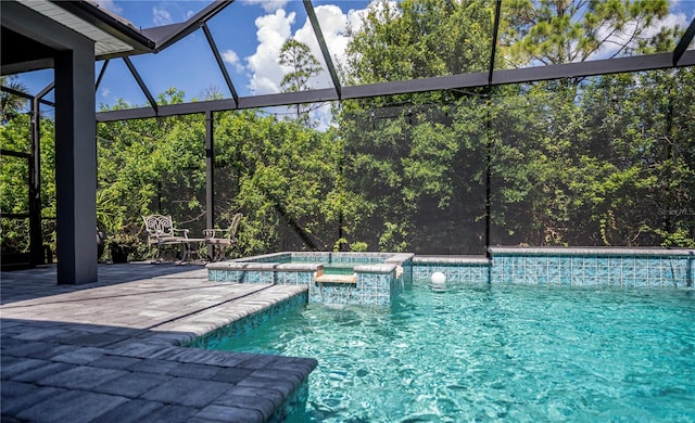 view of swimming pool featuring glass enclosure and an in ground hot tub