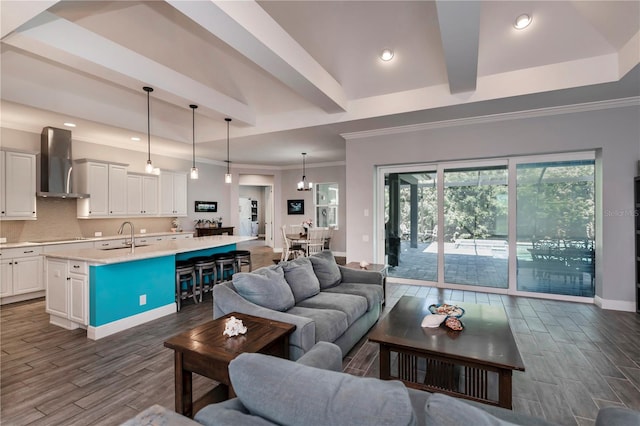 living room featuring dark hardwood / wood-style flooring, sink, and crown molding