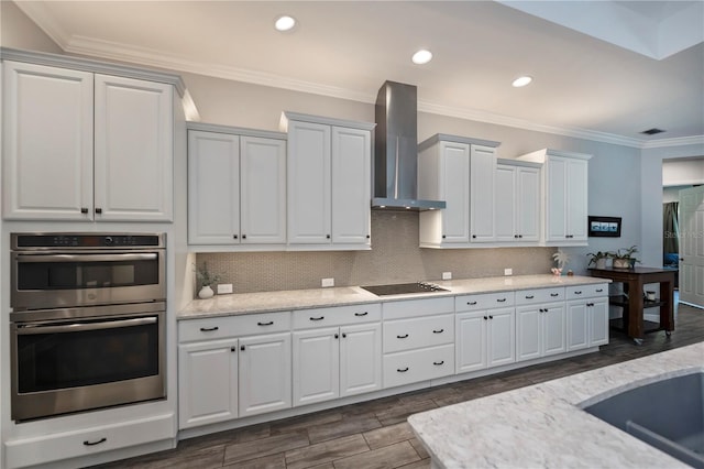 kitchen with white cabinets, wall chimney range hood, black electric stovetop, and double oven