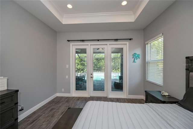 unfurnished bedroom featuring access to exterior, a raised ceiling, dark hardwood / wood-style floors, and crown molding