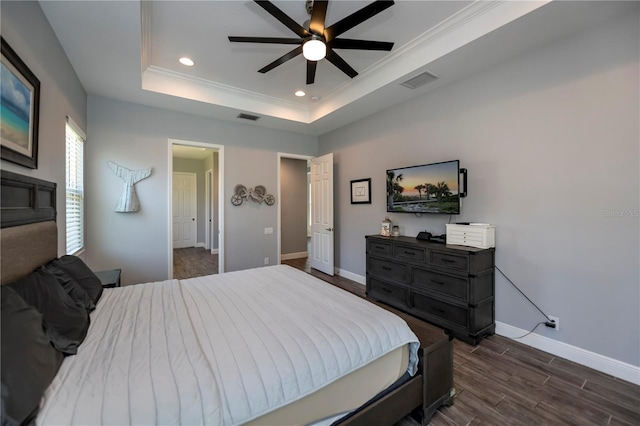 bedroom featuring ceiling fan, dark hardwood / wood-style floors, a raised ceiling, and crown molding