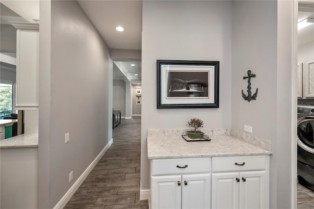 hallway with dark wood-type flooring and washer / dryer