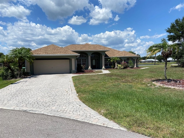 view of front of property with a garage and a front lawn