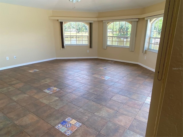 unfurnished room featuring dark tile patterned floors