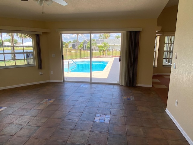 spare room with dark tile patterned flooring and ceiling fan