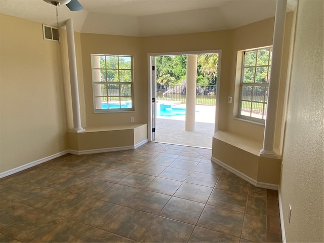 doorway to outside featuring decorative columns and dark tile patterned flooring