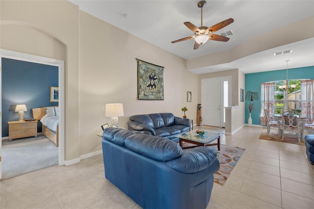 living room featuring ceiling fan with notable chandelier and light tile patterned floors