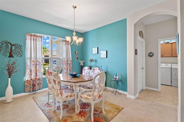 tiled dining room with separate washer and dryer and a notable chandelier