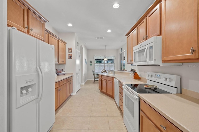 kitchen with white appliances, hanging light fixtures, and light tile patterned floors