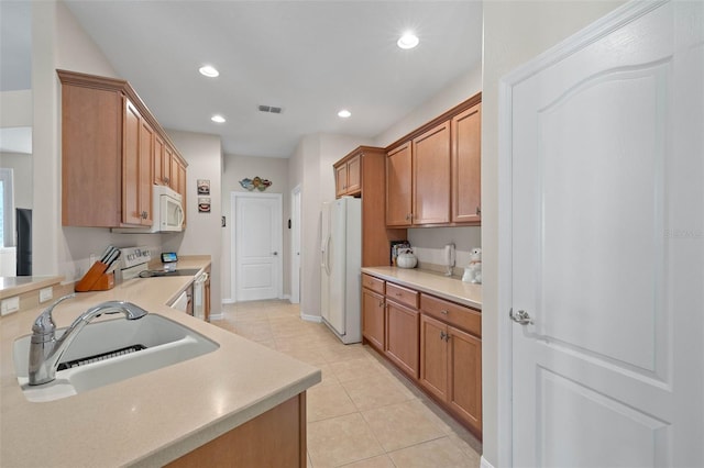 kitchen with light tile patterned flooring, white appliances, and sink