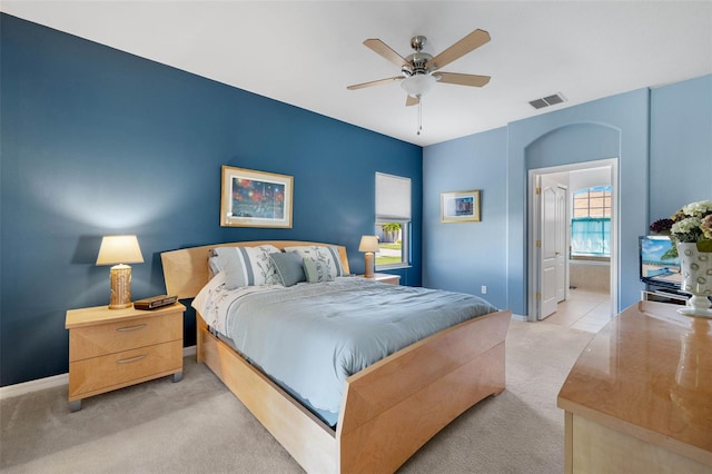 carpeted bedroom with ceiling fan and ensuite bath