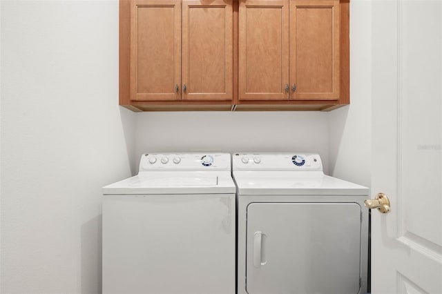 washroom featuring separate washer and dryer and cabinets