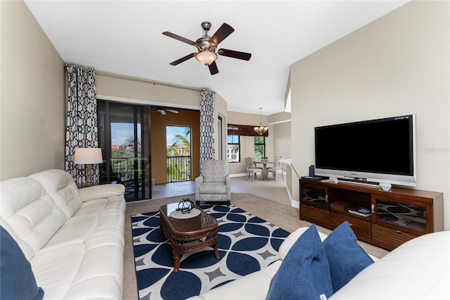 carpeted living room featuring ceiling fan with notable chandelier