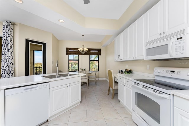 kitchen featuring sink, an inviting chandelier, pendant lighting, white appliances, and white cabinets