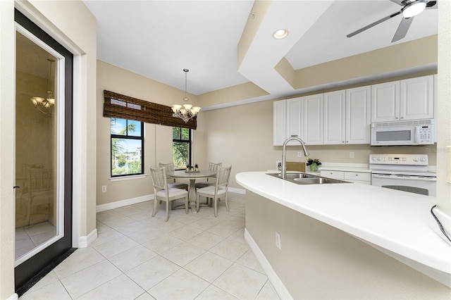 kitchen featuring white cabinetry, sink, decorative light fixtures, white appliances, and ceiling fan with notable chandelier