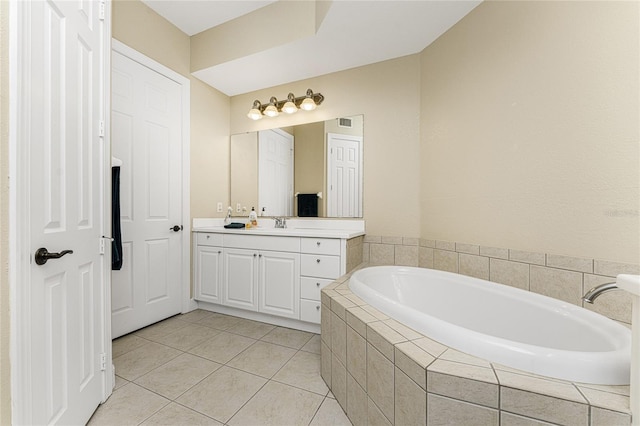 bathroom featuring tiled tub, tile patterned flooring, and vanity