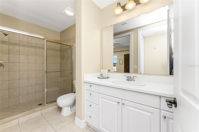 bathroom with tile patterned floors, a shower with door, vanity, and toilet