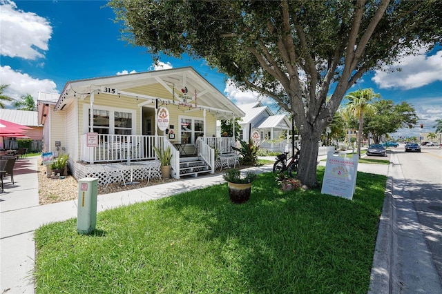 view of front of house featuring covered porch and a front lawn