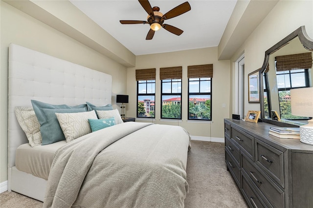 bedroom with light carpet, multiple windows, and ceiling fan