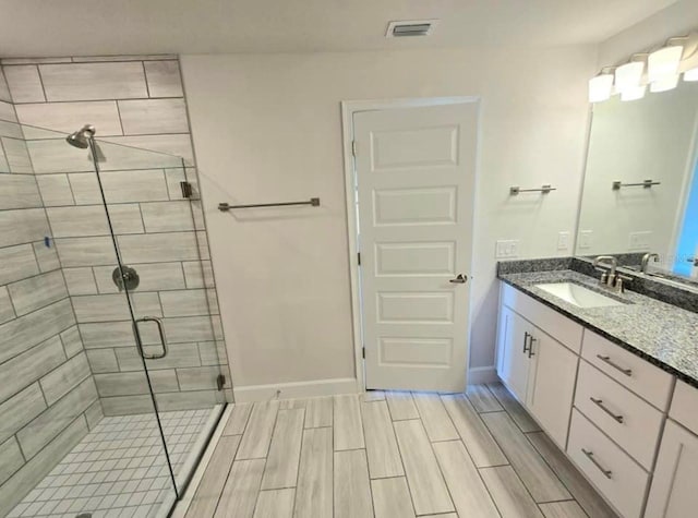 bathroom featuring vanity and a shower with shower door