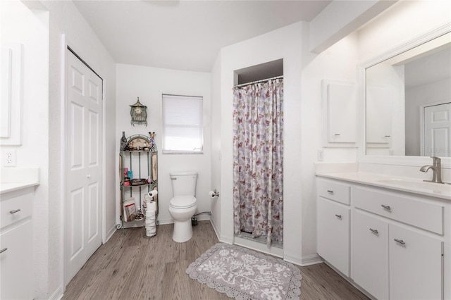 bathroom with a shower with curtain, vanity, toilet, and hardwood / wood-style floors