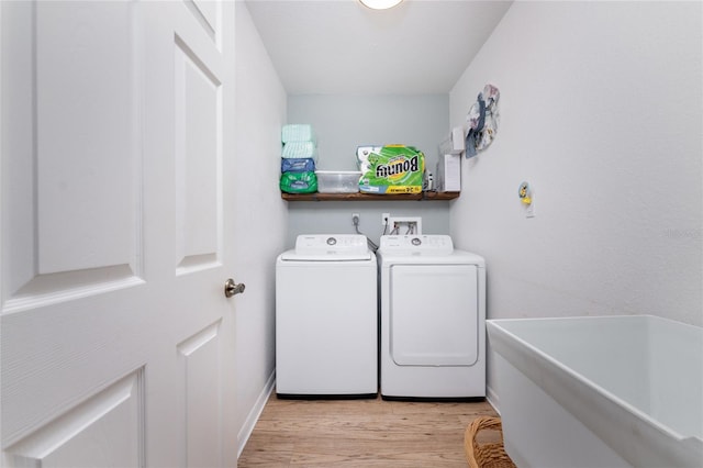 washroom with washing machine and dryer and light wood-type flooring